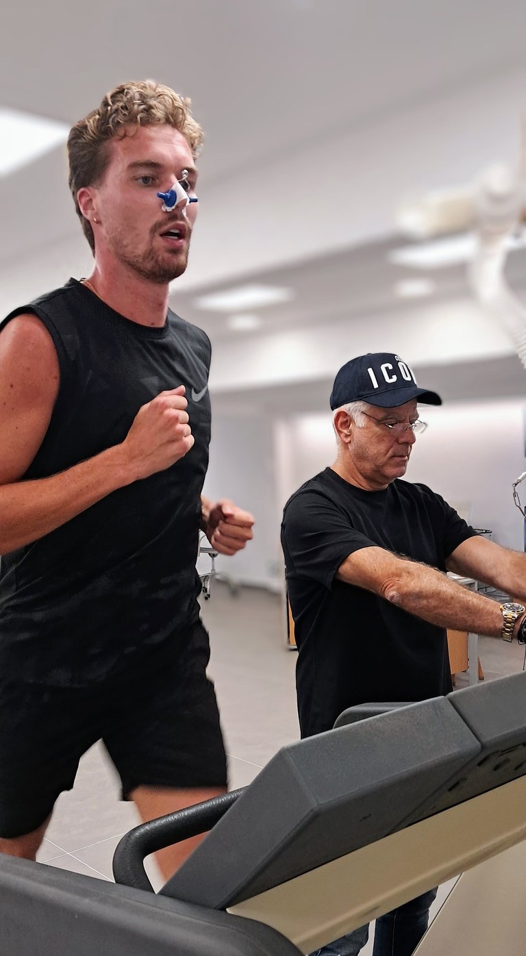 Two men running on treadmills in a gym